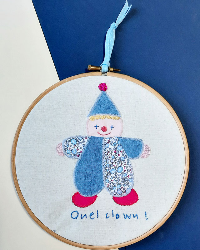 Motif de clown appliqué , phrase brodée main, encadré dans un tambour à broder. A placer en décoration dans une chambre d'enfant.