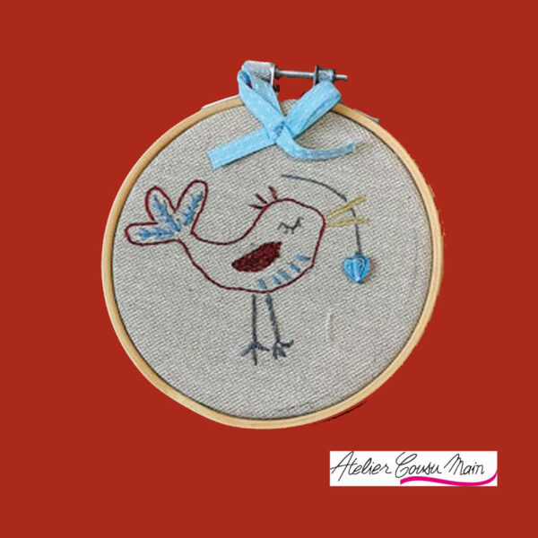 Broderie à la main, d'un petit oiseau encadré dans un mini tambour à broder. A placer en décoration